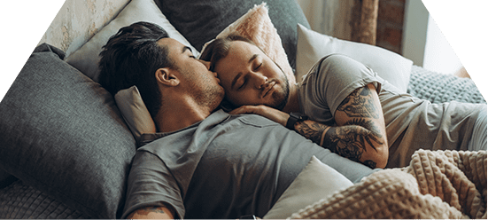 two men laying down together who are in a sexual health program