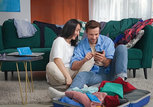 couple looking at phone packing for addiction treatment