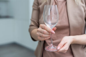 a woman holds an empty wine glass